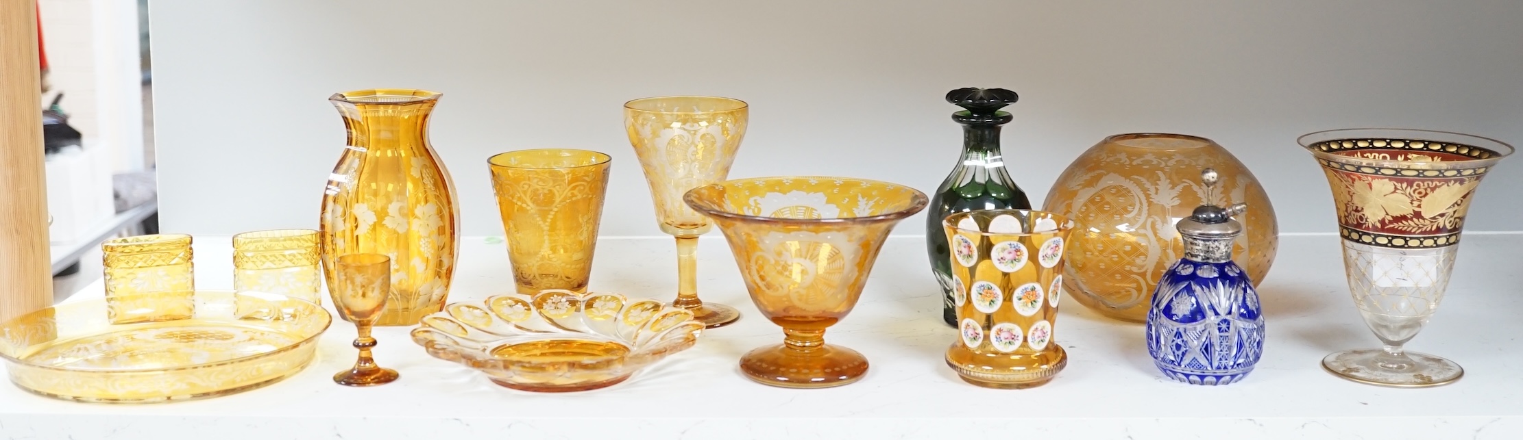 A collection of mostly Bohemian amber flashed cut glassware to include dishes, glasses and a silver topped atomiser, largest 22cm in diameter. Condition - mostly fair